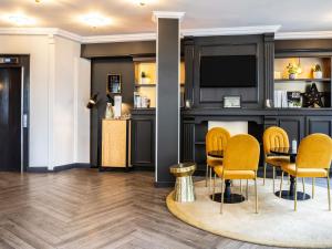 a bar in a room with chairs and a table at ibis Styles Paris 15 Lecourbe in Paris