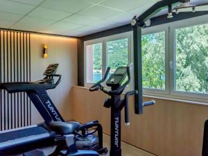 a room with a gym with a treadmill and windows at ibis Loriol Le Pouzin in Le Pouzin