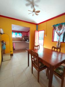 a dining room with a wooden table and yellow walls at Tugbongan North Siargao in Burgos