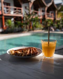 a plate of food and a glass of orange juice at Voodoo Gili in Gili Trawangan