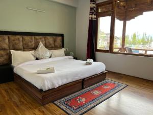 a bedroom with a large bed and a window at Mandalchan hotel in Leh