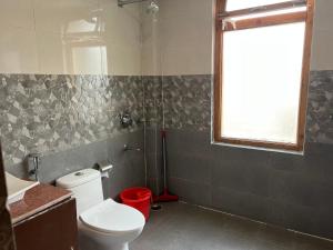 a bathroom with a toilet and a sink and a window at Mandalchan hotel in Leh