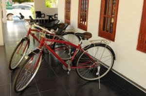 a red bike parked next to a wall at Wild Le Green in Udawalawe