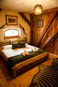 ein Schlafzimmer mit einem großen Bett in einem Zimmer mit Holzwänden in der Unterkunft Hunor Hotel és Étterem in Vásárosnamény
