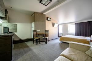a hotel room with a bed and a table and chairs at Grecheskaya Central Suites in Odesa +30 photos
