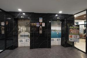 a room with two elevators with black marble walls at Skyview Apartment by Grand Sky Hotel in Sunggal