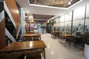 a restaurant with wooden tables and chairs and windows at Skyview Apartment by Grand Sky Hotel in Sunggal