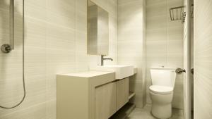 a bathroom with a toilet and a sink and a shower at Skyview Apartment by Grand Sky Hotel in Sunggal +5 photos