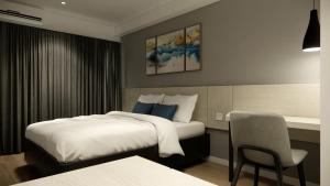 a hotel room with a bed and a chair at Skyview Apartment by Grand Sky Hotel in Sunggal