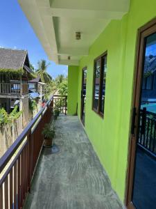 a balcony of a house with green walls at Jaliha Homestay in San Isidro