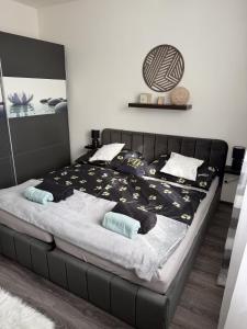 a bedroom with a bed with a black bed frame at Apartmán Mirka in Nový Šaldorf