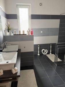 a black and white bathroom with a sink and a mirror at Apartmán Mirka in Nový Šaldorf +5 photos