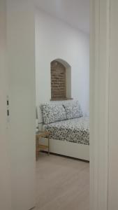 Habitación con cama en habitación blanca en Piazzetta dei Consoli Apartment, en Savona
