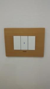 a lightswitch with four white squares on a wall at Piazzetta dei Consoli Apartment in Savona