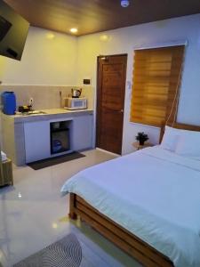 a bedroom with a bed and a kitchen with a sink at Nord House Laoag in Laoag