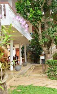 un edificio con alberi e fiori di fronte di Sea Breeze Guest house a Unawatuna