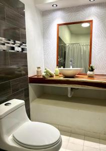 a bathroom with a white toilet and a sink at Casa Alma de Mar in Brisas de Zicatela +28 photos