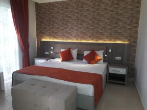 a bedroom with a large bed with red and orange pillows at Lykia Botanika Beach Fun & Club - All Inclusive in Fethiye