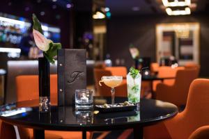 a black table with a drink on it in a restaurant at The Fitzwilliam Hotel Belfast in Belfast