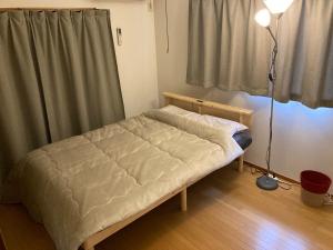 a small bed in a room with a lamp at Osaka Convenient Location Entire Private Second Floor in Hirakata +18 photos