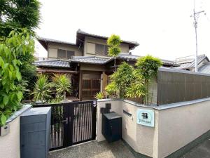 a house with a black fence and a gate at Osaka Convenient Location Entire Private Second Floor in Hirakata