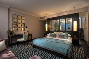 a bedroom with a bed and a desk and a chair at The Fitzwilliam Hotel Belfast in Belfast +31 photos