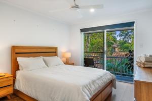 a bedroom with a bed and a large window at Treetops Sunrise Beach in Byron Bay