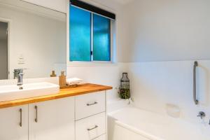 a bathroom with a sink and a tub and a window at Treetops Sunrise Beach in Byron Bay +30 photos