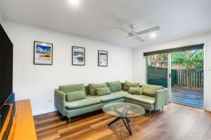 a living room with a couch and a table at Treetops Sunrise Beach in Byron Bay