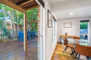a dining room with a table and chairs on a deck at Treetops Sunrise Beach in Byron Bay