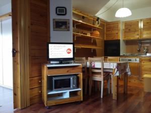 a kitchen with a table with a tv on top of it at Appartamento Artuik in Marilleva