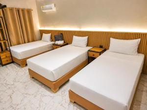 a hotel room with two beds and two tables at Hotel Cafe Boutique in Pereira