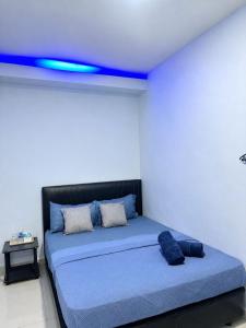 a bed in a room with a blue ceiling at Ilhamku Inn in Kampong Kemaman