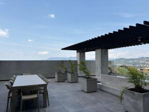 a patio with a table and chairs on a roof at Estudio 905 in San Salvador