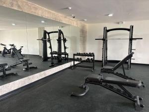 a gym with several tread machines and a mirror at Estudio 905 in San Salvador