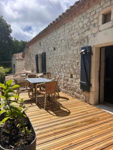 a wooden deck with a table and chairs on a building at Les fontanelles du quercy blanc in Montcuq