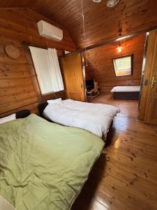 a bedroom with two beds in a wooden cabin at Based Inn Okayama Kurashiki in Okayama