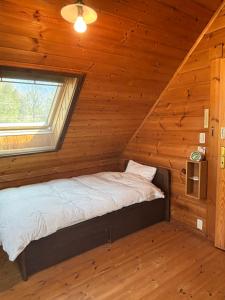 a bed in a log cabin with a window at Based Inn Okayama Kurashiki in Okayama