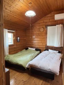 a bedroom with two beds in a log cabin at Based Inn Okayama Kurashiki in Okayama