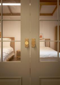 a room with a door with mirrors and two beds at 스테이 모슬 in Daejeong