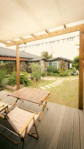 a wooden deck with a picnic table and chairs at 스테이 모슬 in Daejeong