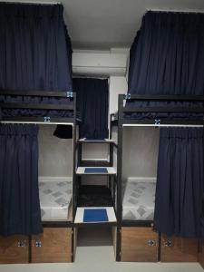 two bunk beds in a room with blue curtains at 7641guesthouse in Basdiot