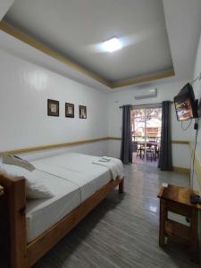 a bedroom with a bed and a television and a table at Villa Loreta Beach Resort in Zambales +14 photos