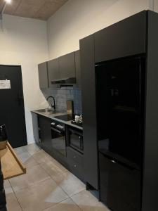 a kitchen with black cabinets and a stove top oven at Sandton CBD apartment in Johannesburg