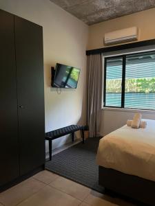 a hotel room with a bed and a flat screen tv at Sandton CBD apartment in Johannesburg