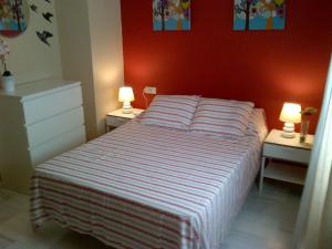 a bedroom with a bed with two lamps on two tables at Triana Pureza in Seville