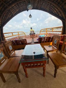 a boat with a table and chairs on a boat at Traditional Houseboat in Alleppey