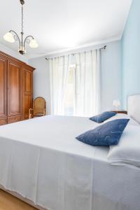 a bedroom with a large white bed with blue pillows at Al Centro - Gaeta in Gaeta +13 photos