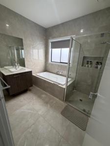 a bathroom with a shower and a tub and a sink at Private Room in Rockbank in Rockbank +10 photos
