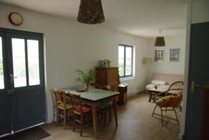 eine Küche und ein Esszimmer mit einem Tisch und Stühlen in der Unterkunft Gîte De La Tulipe in Guéméné-Penfao